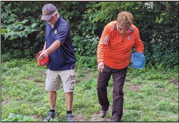 Park Commissioners Bill Cameron and Sandy Wiechman spread seeds they collected on a section of ground at Bradner Preserve.