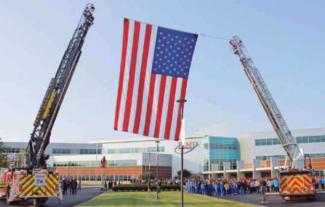 Perrysburg Township and Pemberville fire departments raise the American flag prior to the ceremony at Penta Career Center.