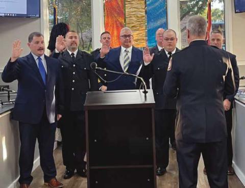 Full-time firefighters, from left: Zachary Bernhard, Zachery Moore, Ryan Goodrick, Michael Roberts and Josh Walters, being sworn in by Fire Chief Rick Syroka (with back toward camera). Assistant Chief Ron Kay and Mayor Neil MacKinnon III can be seen in the background.