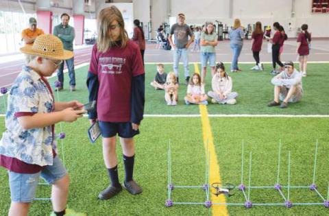 Above: Students practice navigating drones through obstacles courses. Below: Perrysburg Township Fire Department demonstrates how drones can be used to deliver life vests in a rescue scenario.