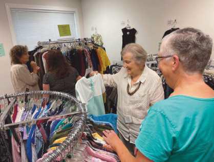 Volunteers arrange items at the the Clothesline, a free clothing store offered through the Timothy’s Perrysburg Foundation.