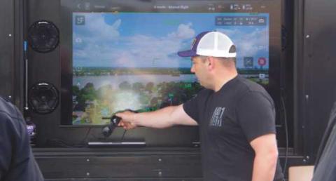 State Representative Haraz Ghanbari points out features on the interface of the drone controls.