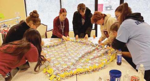 Rossford NHS members work on one of forty fleece blankets.