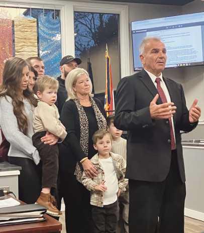Fire Chief Syroka, right, speaks to the city council audience with his family beside him.