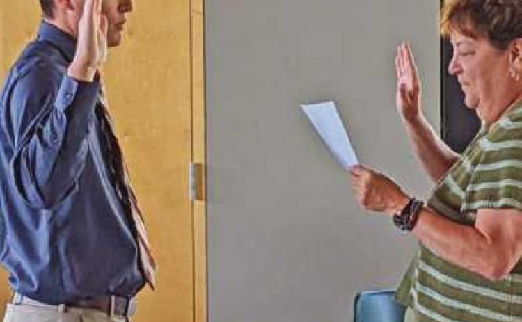 Park board president Sandy Wiechman, right, administers the oath of office to the newest park police officer Brett Foos of Perrysburg.