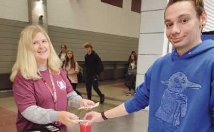 The store’s first staff customer, Marlene Sizemore, served by student, Sean Klocko.