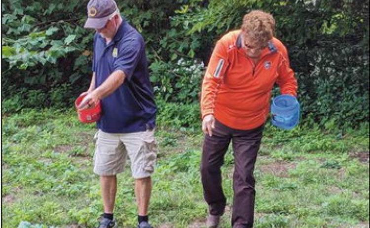 Park Commissioners Bill Cameron and Sandy Wiechman spread seeds they collected on a section of ground at Bradner Preserve.