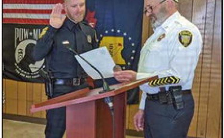 Sergeant Dustin Glass is administered the oath of office by Police Chief Mark Hetrick.