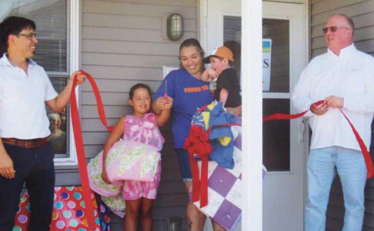 At the ribbon-cutting ceremony are, from left: Mark Ohashi, executive director of Habitat for Humanity of Wood County; Leticia Hernandez and her family, and Rossford Mayor Neil MacKinnon III.