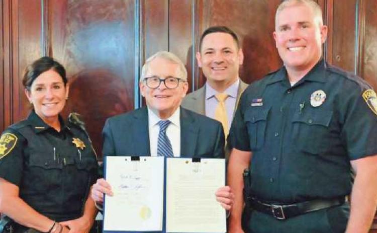 State Representative Haraz Ghanbari and Ohio Governor Mike DeWine are joined by Lake Township Police Department Officer Kelly Clark, left, and Perrysburg Township Police Detective Chris Klewer for the signing of House Bill 206 on June 24.