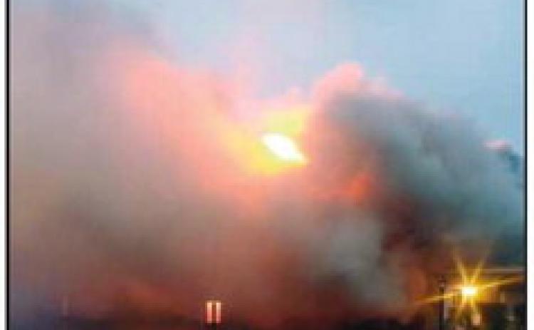 Smoke billows around the flames as firefighters work to get the fire under control.