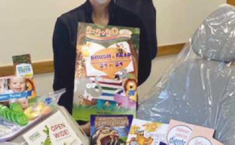 Dental assistant Merrilee Ewing-Beckley displays a few of the donated items that will be used to educate and improve dental care.