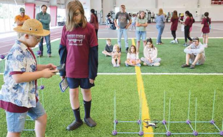 Above: Students practice navigating drones through obstacles courses. Below: Perrysburg Township Fire Department demonstrates how drones can be used to deliver life vests in a rescue scenario.