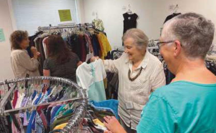 Volunteers arrange items at the the Clothesline, a free clothing store offered through the Timothy’s Perrysburg Foundation.
