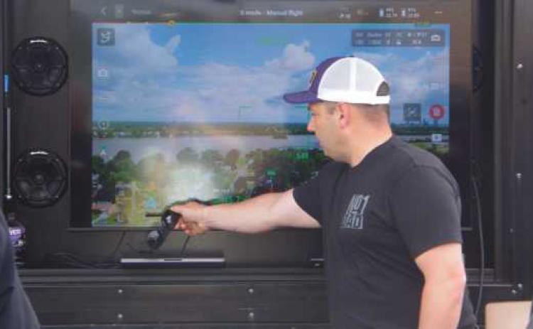 State Representative Haraz Ghanbari points out features on the interface of the drone controls.