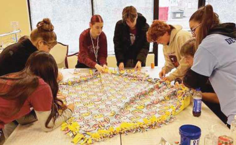 Rossford NHS members work on one of forty fleece blankets.