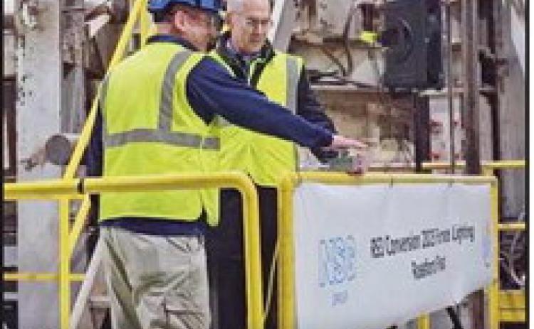 Joe Gyurasics and Todd Huffman press the button for the ceremonial furnace lighting.