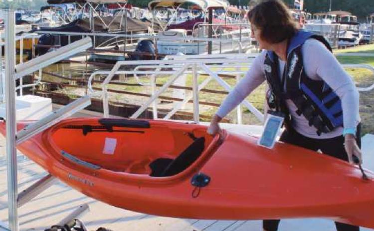 Top, Mrs. Krafty demonstrates how she slides her kayak off the main dock and into the racks toward the gangway.