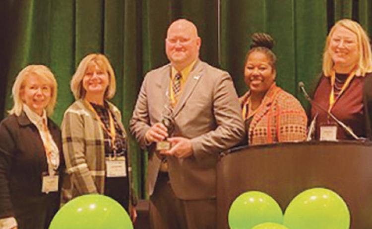 TARTA Chief Customer Experience and Mobility Officer Rick Bailey, center, with the OPTA Collaborative Excellence Award. He was joined on stage by Destination Toledo President and CEO Lance Woodworth, TARTA CEO Laura Koprowski, and TARTA Trustees Mary Morrison, Kendra Smith and Brittany Ford.