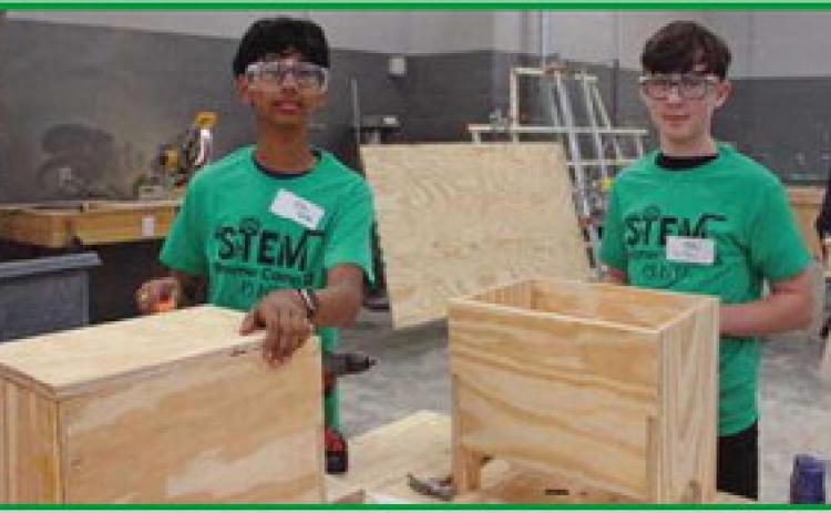 Rishabh Jha, an eighth grader, and Ethan Brown, ninth grader at Rossford schools, learn how to construct wooden storage boxes.