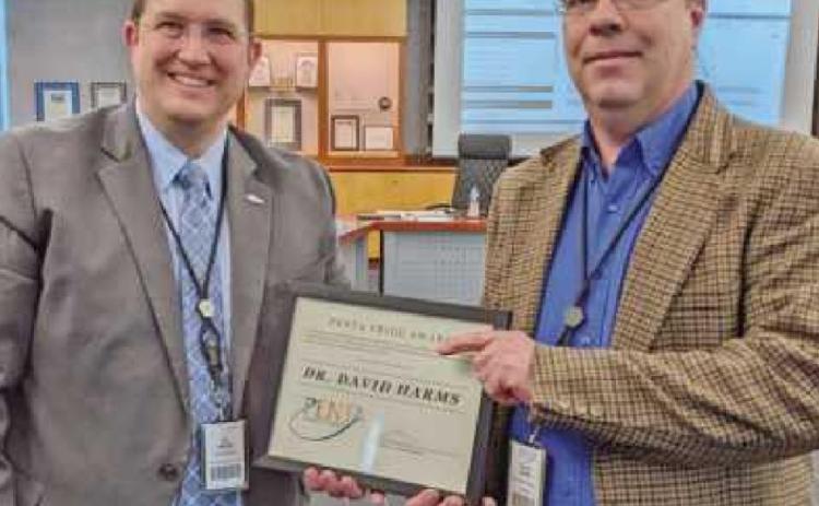 Superintendent Ed Ewers, left, congratulates Dr. David Harms, social studies instructor, on receiving the Armenian National Committee of America’s Armenian Genocide Education award.